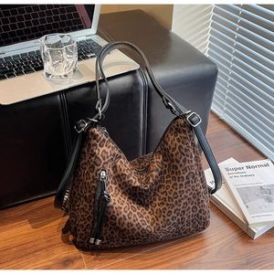 Detailed view of leopard print crossbody bag with silver buckle and tassel zipper pocket