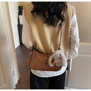 Vintage brown leather crescent shoulder bag with gold buckle and plush rabbit charm