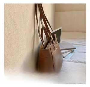 Detailed view of brown leather tote bag with sturdy straps in a modern lifestyle setting
