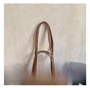 Detail of brown leather tote bag showing double shoulder straps and fine stitching