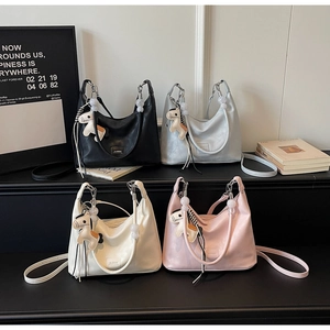 Détail de quatre sacs hobo en cuir souple de différentes couleurs avec charms cheval