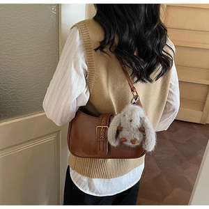 Retro brown leather shoulder bag with gold buckle and a cute grey plush rabbit charm