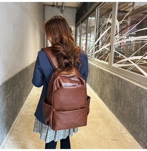 Detail of a brown vintage PU leather backpack featuring adjustable straps and soft texture