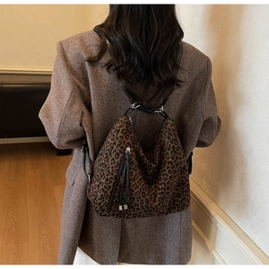 Rear view of a model wearing the large leopard print shoulder bag with tassel details