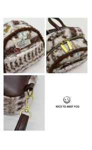 Detail of plush animal print mini backpack with brown leather strap and gold hardware