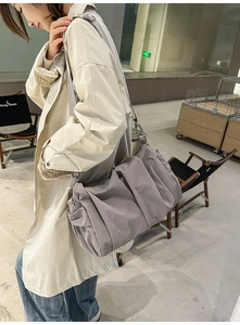 Detail view of large pleated shoulder bag with adjustable strap for daily commute