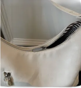 Détail de la fermeture éclair en métal argenté et de la doublure rayée du sac cabas