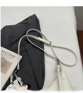Détail de la bandoulière réglable en cuir blanc avec charm animal de dessin animé mignon