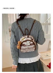 Detail of plush faux fur mini backpack with brown animal pattern and cute bear charm
