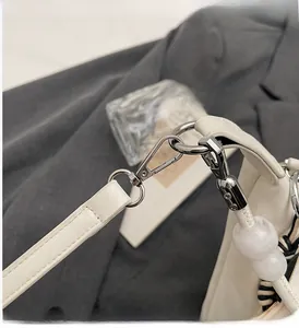Détail de la boucle en métal argenté avec perles de marbre sur la bandoulière en cuir