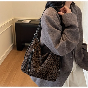 Detailed view of leopard print hobo bag with black leather strap and long tassel zipper