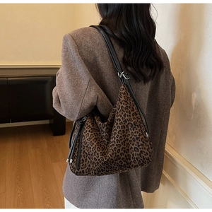 Detail of leopard print crossbody bag with black leather strap and silver metal buckle