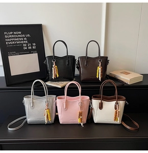 Five assorted colors of mini bucket bags with beaded charms shown in a tiered display