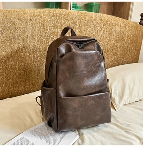 Detail of dark brown vintage PU leather backpack with a smooth texture and dual zippers