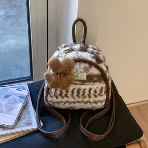 Detail of plush fleece mini backpack with brown wave pattern and cute charm