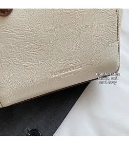 Detail of soft lychee pattern leather handbag with embossed fashion logo and neat stitching