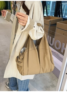 Detail view of khaki large capacity nylon tote bag with side pocket and soft texture