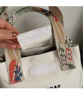 Detail showing Velcro closure and ethnic floral embroidery on a canvas bucket bag