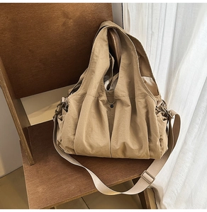 Detail view of khaki large capacity tote bag on wooden chair with natural light