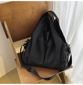 Detail of black waterproof tote bag with pleated texture and side storage pockets
