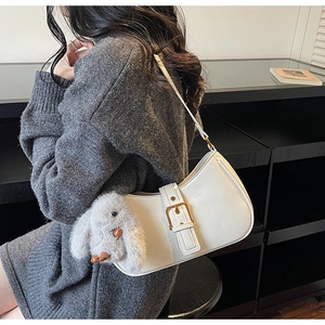 Close-up of white crescent shoulder bag with matte leather and bunny charm