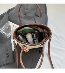 Internal view of beige bucket bag showing spacious storage for makeup and smartphone