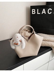 Détail du sac seau beige avec texture cuir litchi et pendentif lapin gris mignon