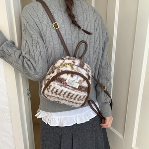Detail of plush mixed-brown mini backpack showing furry texture and cat embroidery