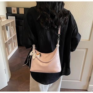 Vue arrière détaillée du sac hobo rose avec breloque cheval porté par un mannequin