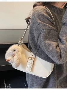 White glossy leather crescent shoulder bag with gold buckle and cute plush bunny charm