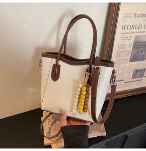 Close-up of retro color-block bucket bag with rainbow wooden beads and fashion stamp