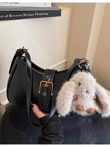 Glossy black patent leather underarm bag with gold buckle and plush rabbit charm