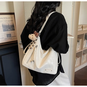 Détail du grand sac cabas en similicuir crème avec pompon et breloque ours peluche