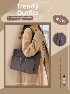 Detail of dark grey canvas tote bag with dual parallel front zippers and brand woven label