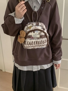 Mini plush backpack with cat patch and bear charm worn by model in vintage style