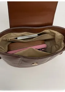 Interior view of brown leather bucket bag showing compartments with phone and eyewear
