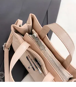 Détail de la fermeture éclair en métal et du loquet rotatif sur le sac à main beige chic