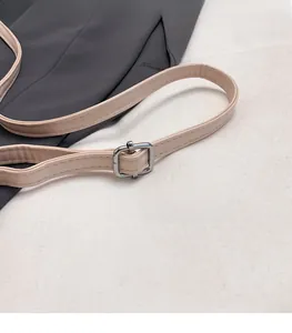 Vue détaillée de la bandoulière en cuir beige grainé avec boucle en métal argenté