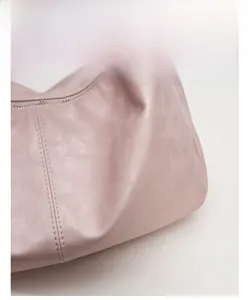 Detailed close-up of soft matte pink fabric with precise reinforced double stitching