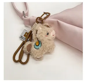Cute alpaca plush bag charm with rainbow embroidery on pink leather tote bag