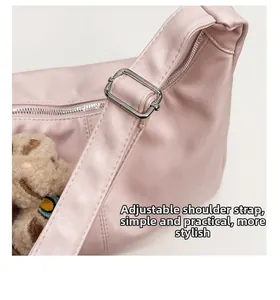 Detail of adjustable strap and silver buckle on pink leather tote bag with plush bear charm