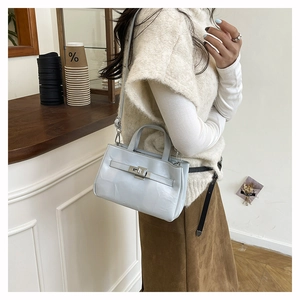 Détail d'un sac à main bleu clair en cuir verni brillant avec boucle en métal