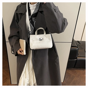 Détail d'un mini sac seau blanc avec texture cuir et fermoir en métal