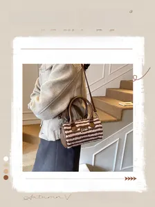 Detailed close-up of a striped plush pillow bag featuring white Love embroidery and leather trim
