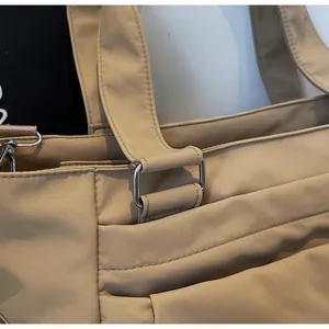 Gros plan détaillé du tissu beige et de l'anneau métallique argenté poli du sac fourre-tout