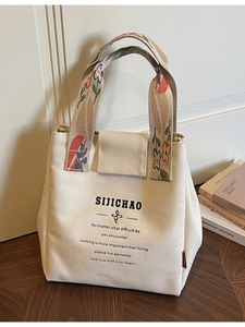 Canvas bucket bag with floral handles and inspirational text shown in an indoor setting