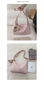 Detail of light pink hobo bag featuring soft faux leather texture and a plush bear charm
