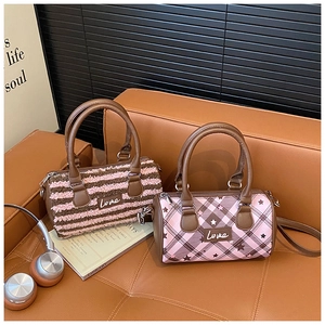 Detail of Boston bags showing plush striped material and pink plaid with Love embroidery