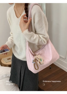 Detailed side view of pink large-capacity faux leather tote bag with plush animal charm