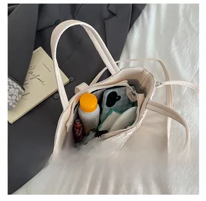 Spacious interior of a cream woven bucket bag showing daily essentials and long strap
